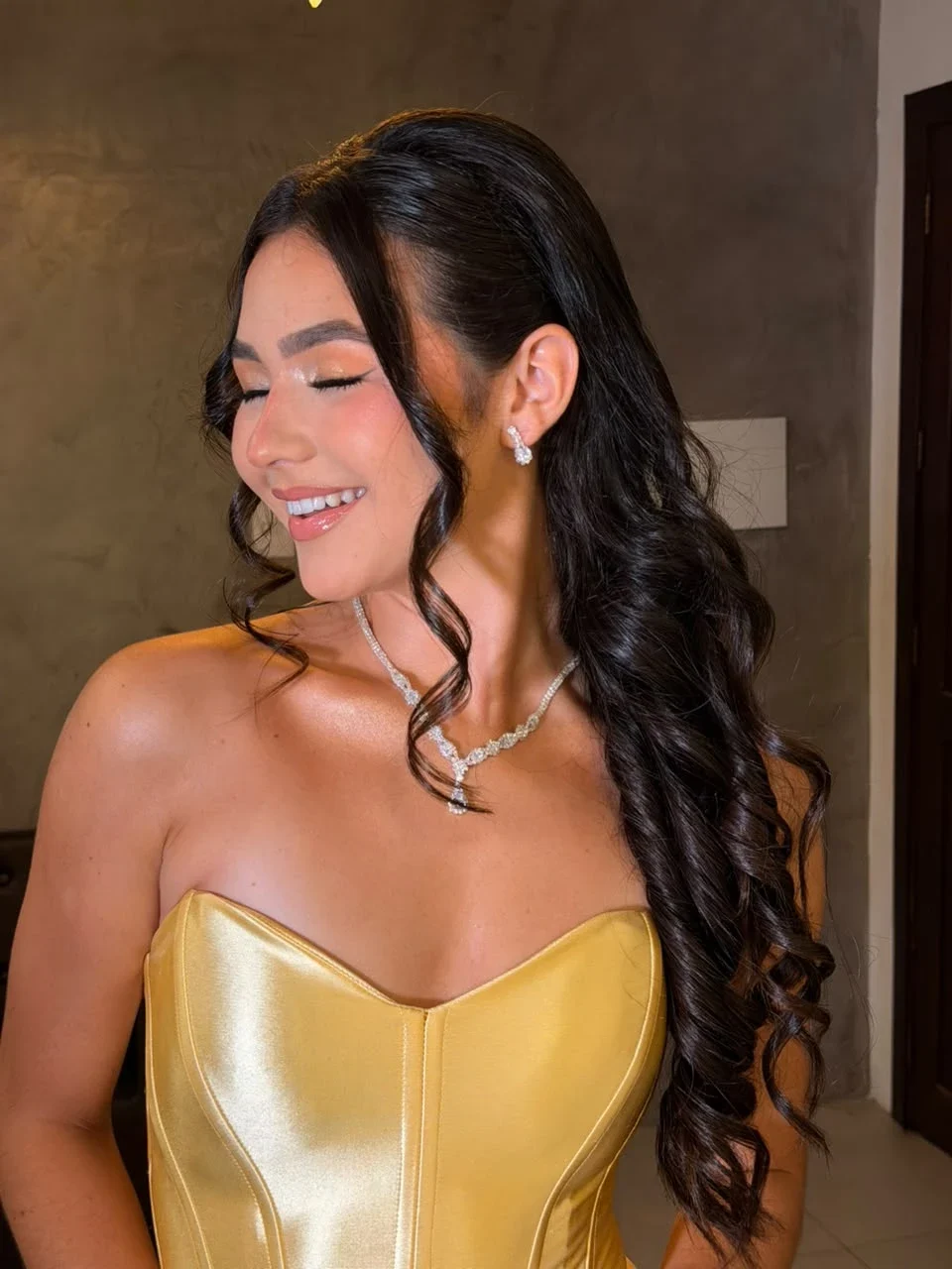 Cliente com cabelo escuro em cachos e maquiagem